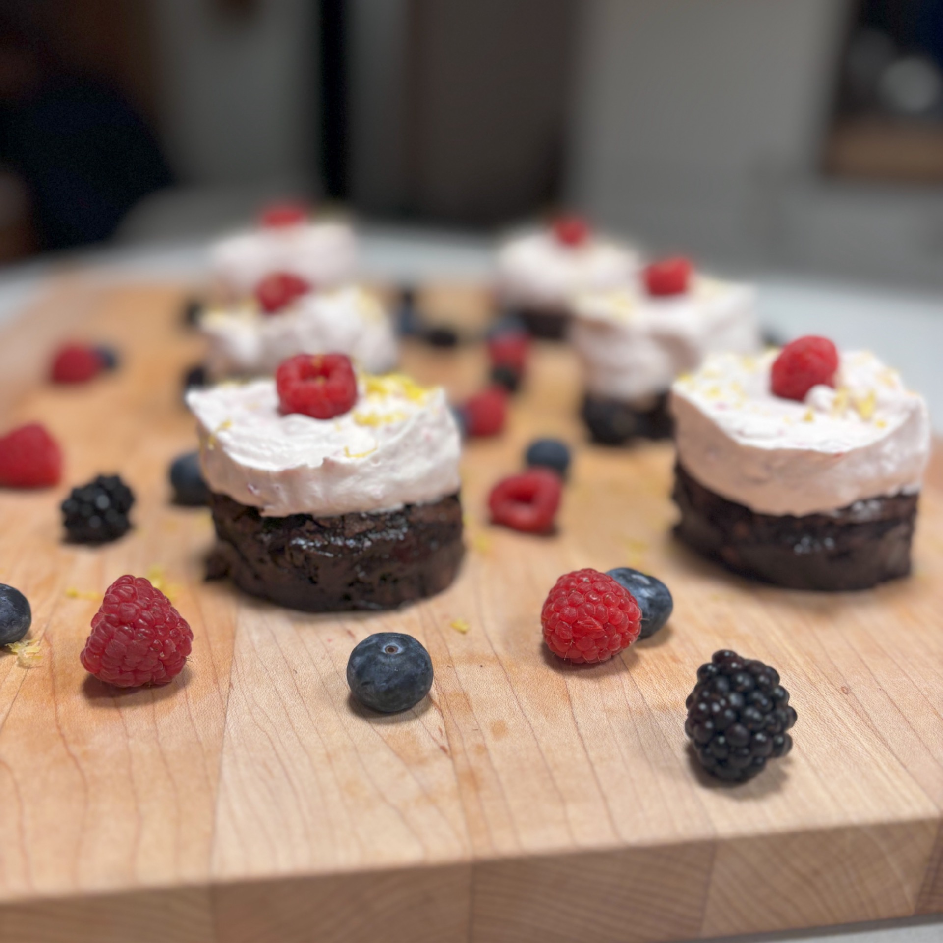 Tray of mini fudgy brownies with raspberry and lemon whipped cream