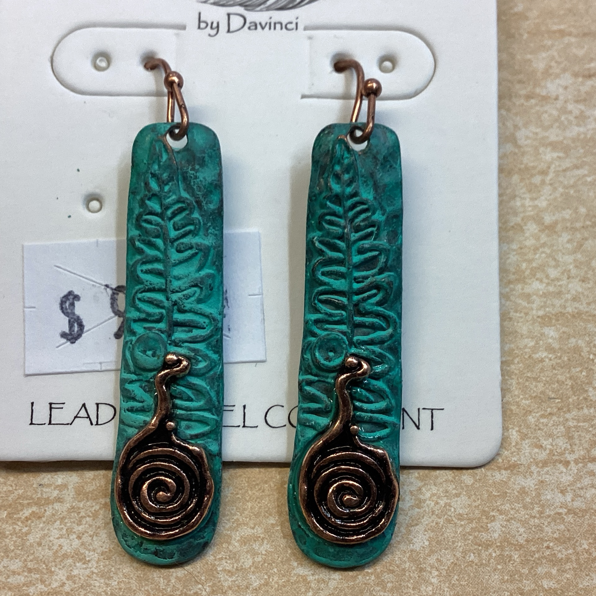 Patina toned long dangle with swirl in copper tone on bottom