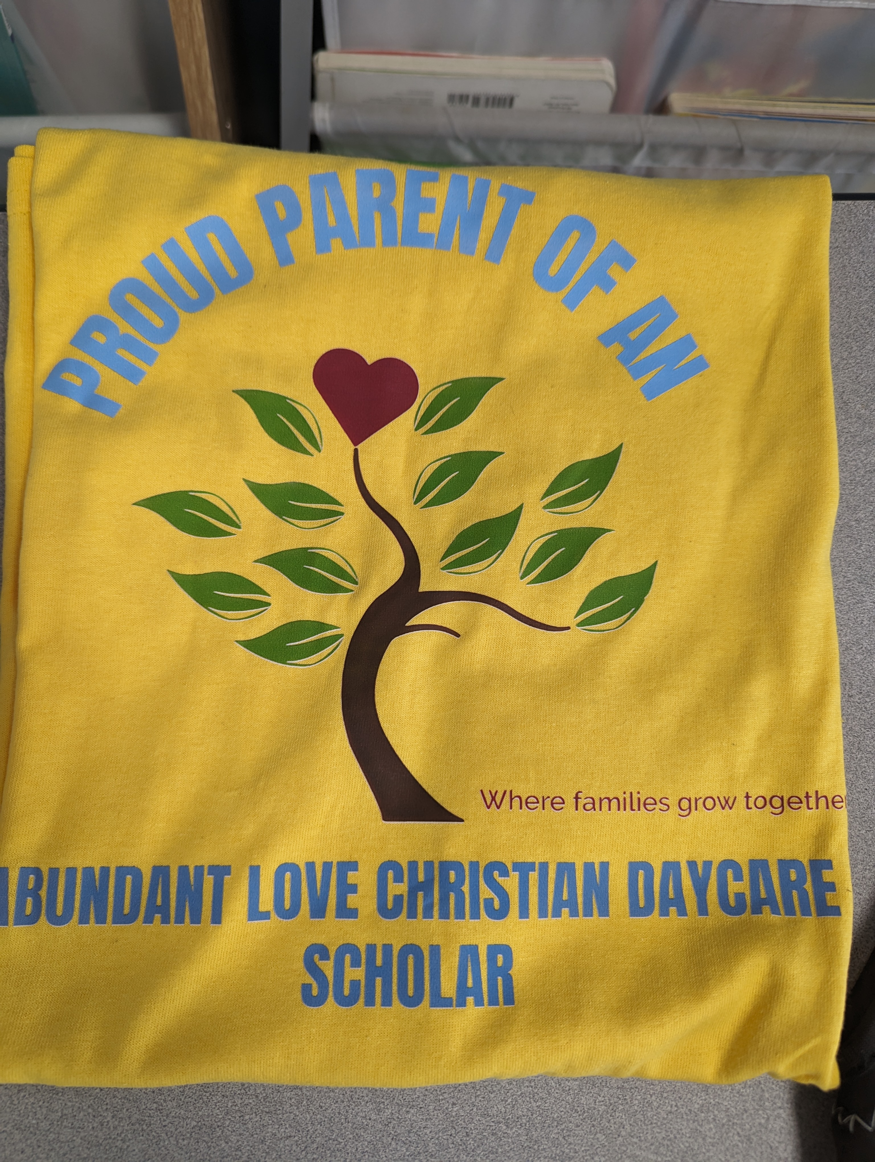 Yellow t-shirt with "Proud Parent" in Carolina Blue and the school's logo.
