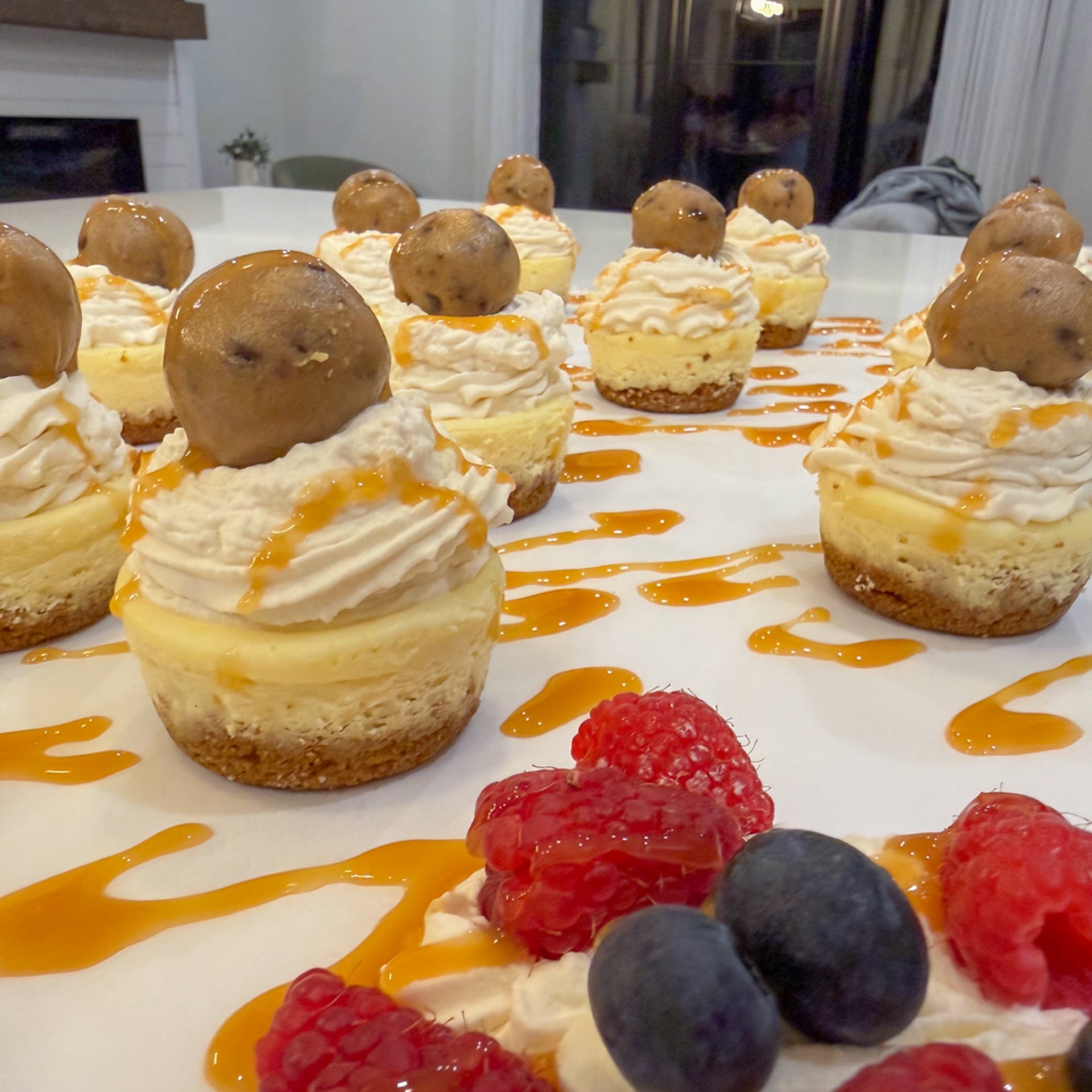 Tray of mini cheesecakes with caramel whipped cream and biscuit base
