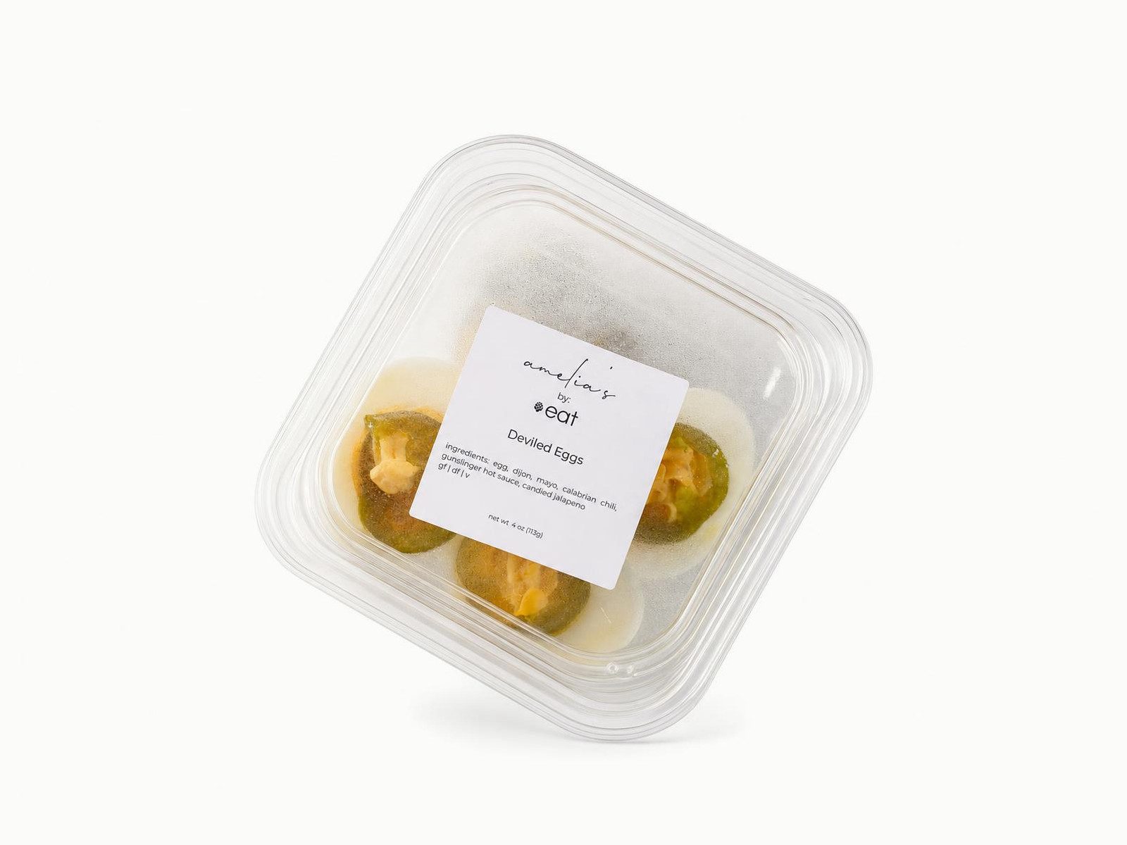 Amelia's spicy deviled eggs with jalapeño in a clear to-go container