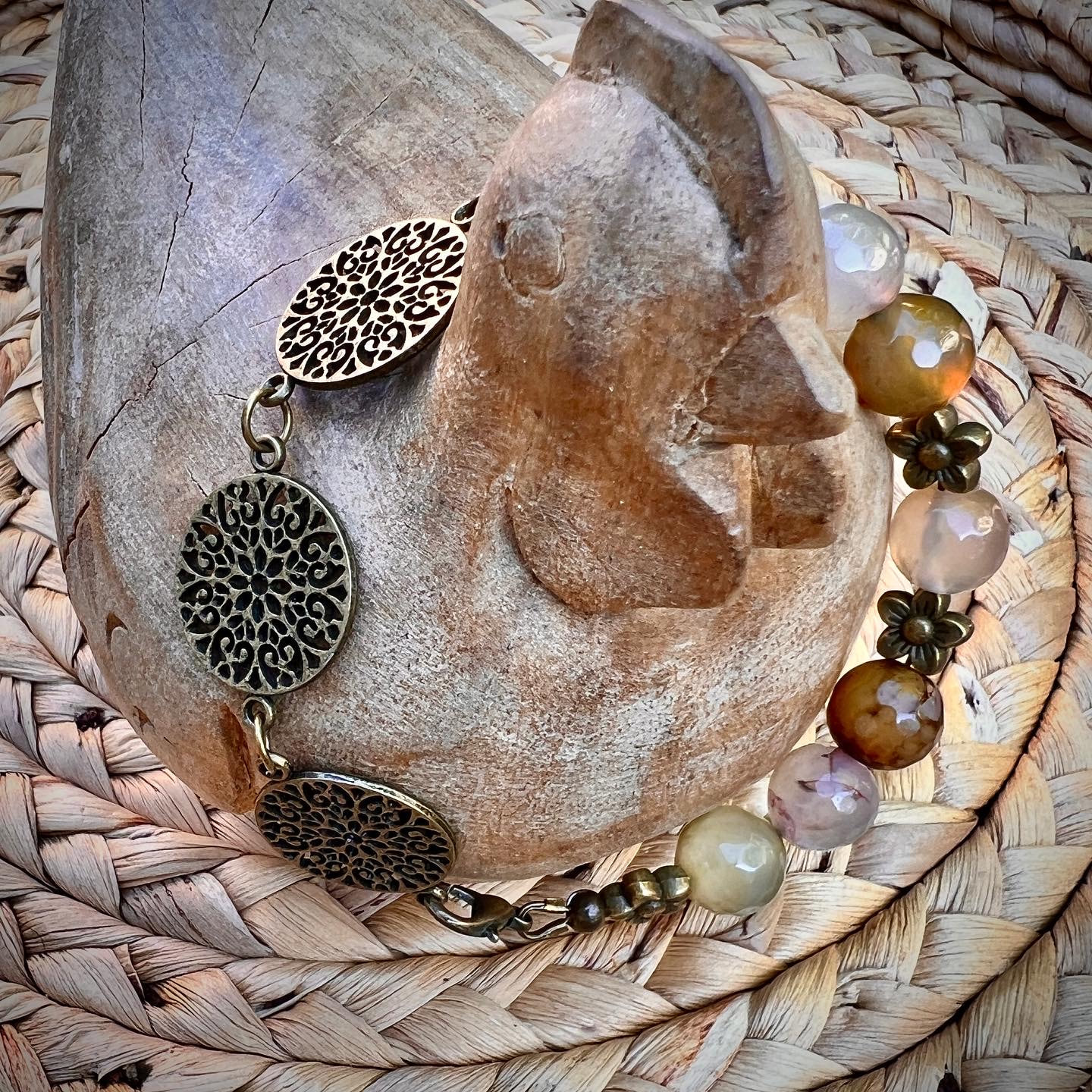 7” Tibetan 3 Coin Filigree with Multi Color Faceted Agate & Antique Brass Tone Flower Beads. Wired on Softflex. Lobster clasp.