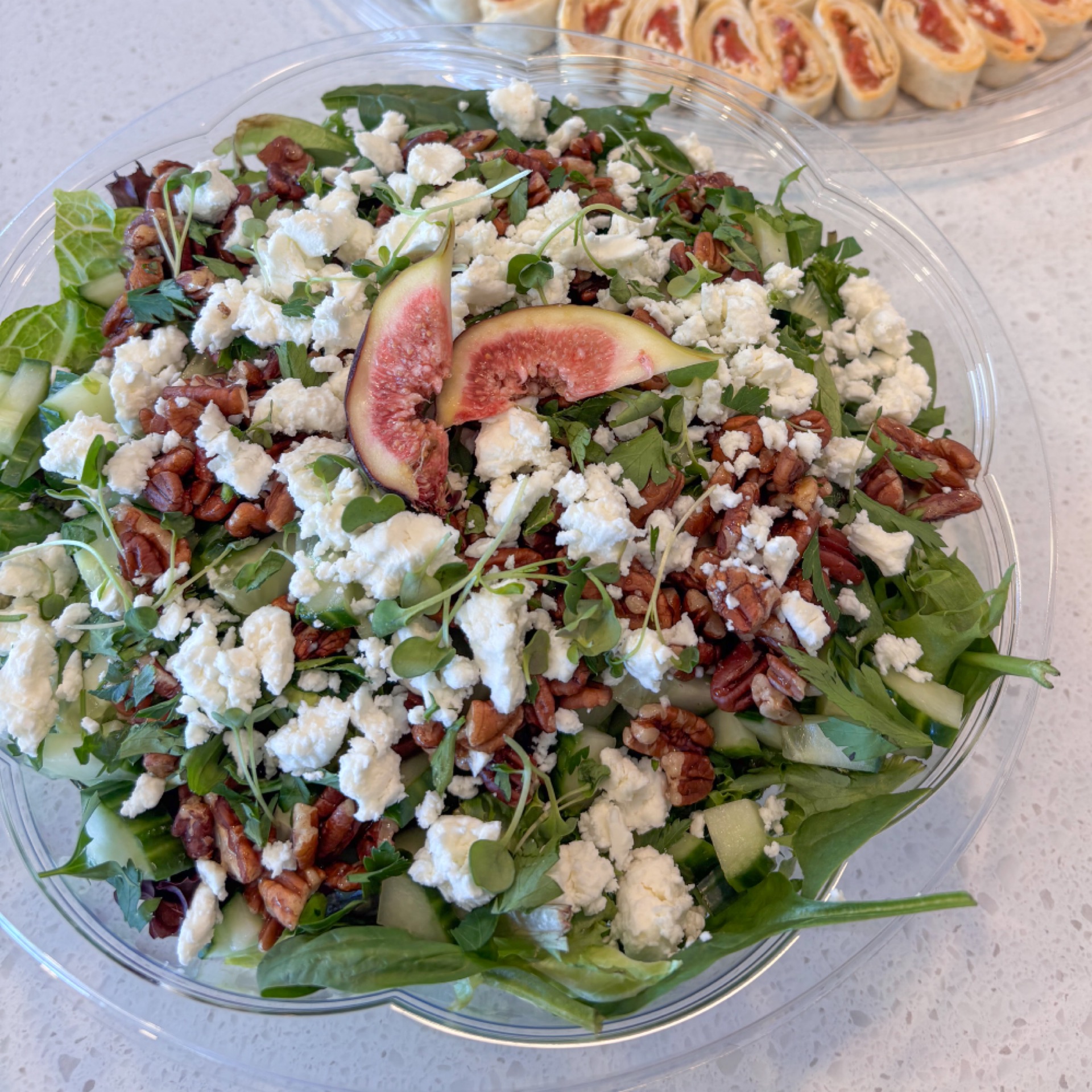 Green salad bowl with maple pecans, cucumbers, cranberries and goat cheese with homemade maple dressing