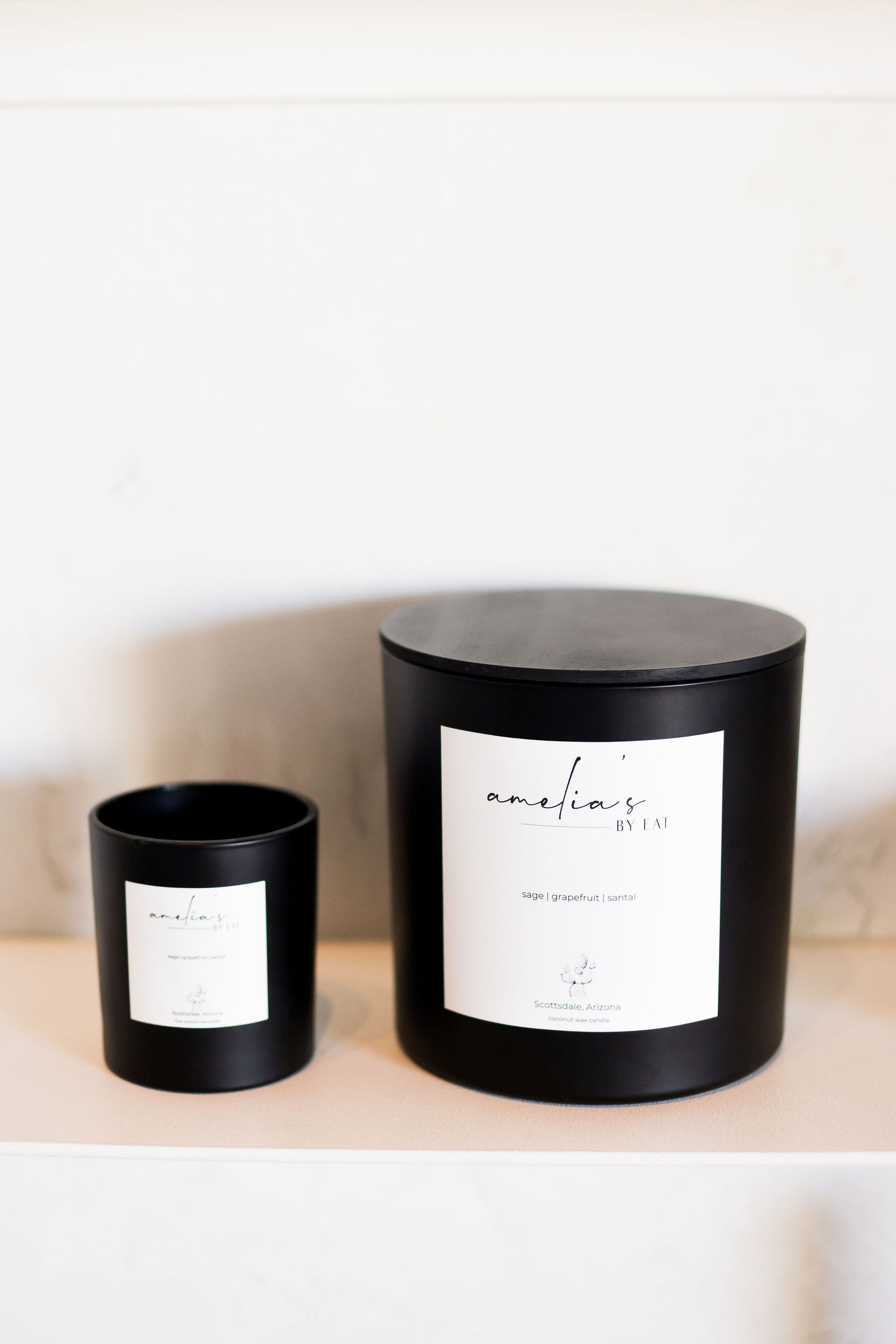 Two Amelia's by EAT black candles, small and large, labelled sage, grapefruit and santal