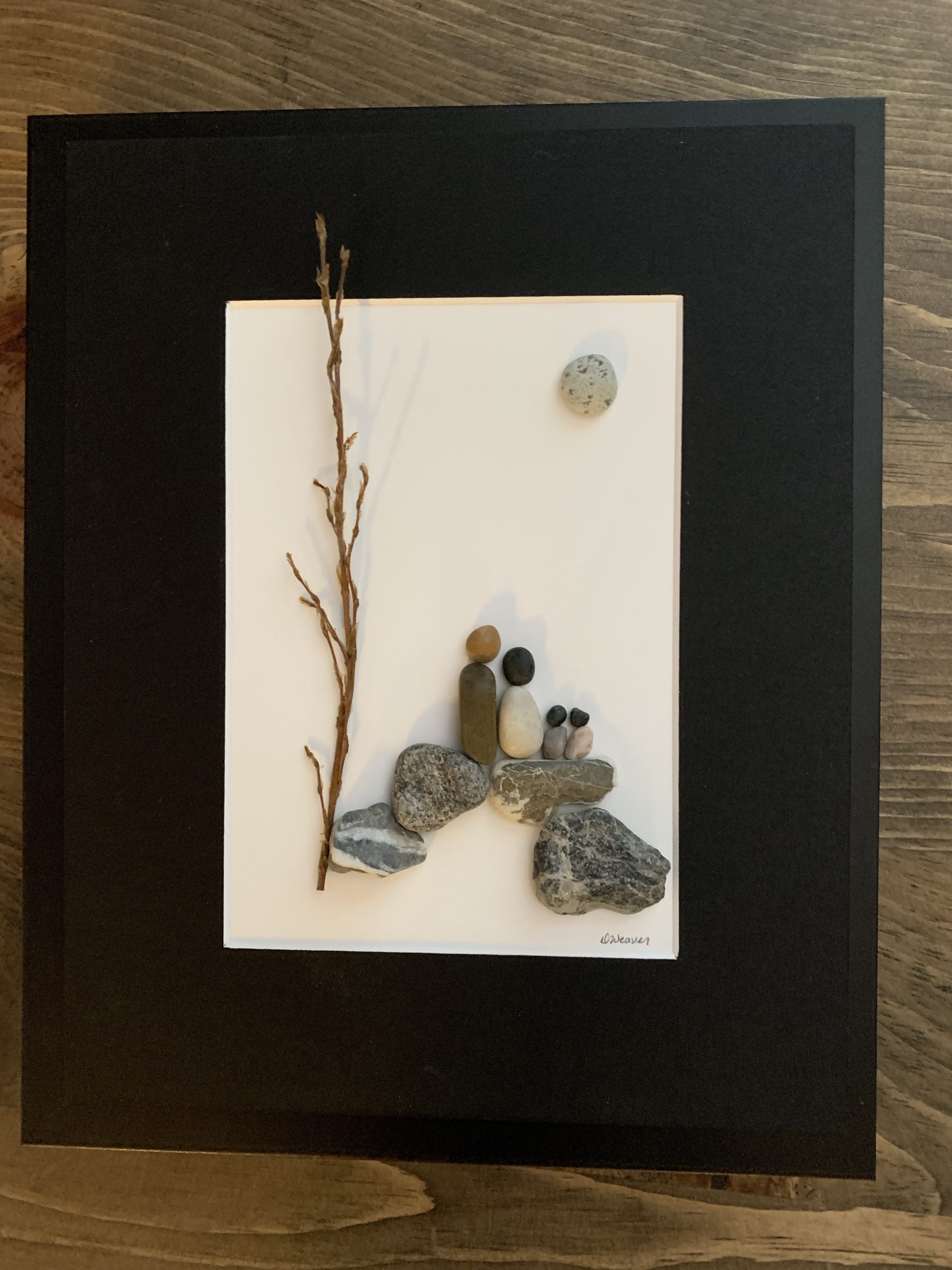 Family of 4 standing on rocks by a tree