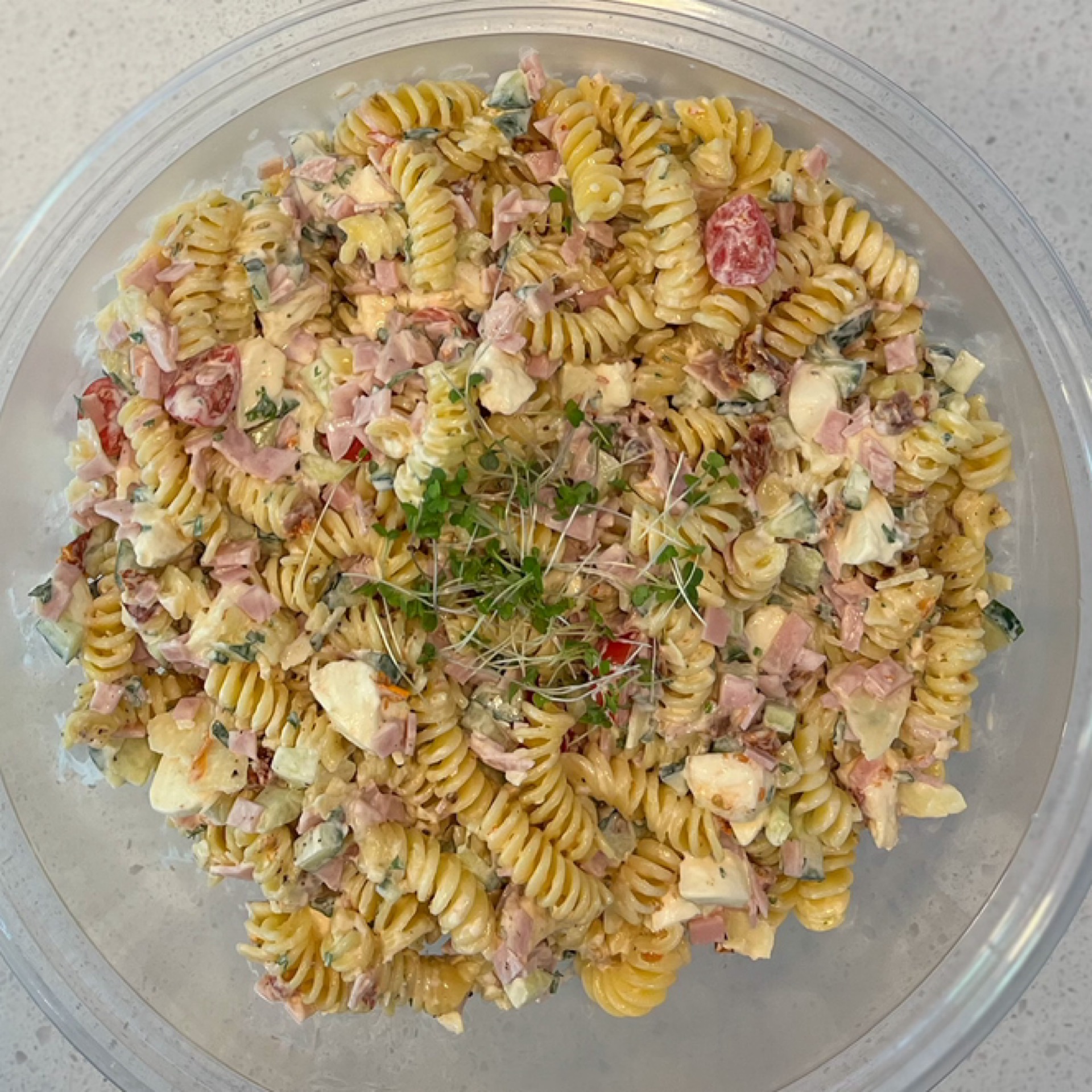 Bowl of pasta salad, bocconcini, tomatoes, ham, cucumber & truffle mayo