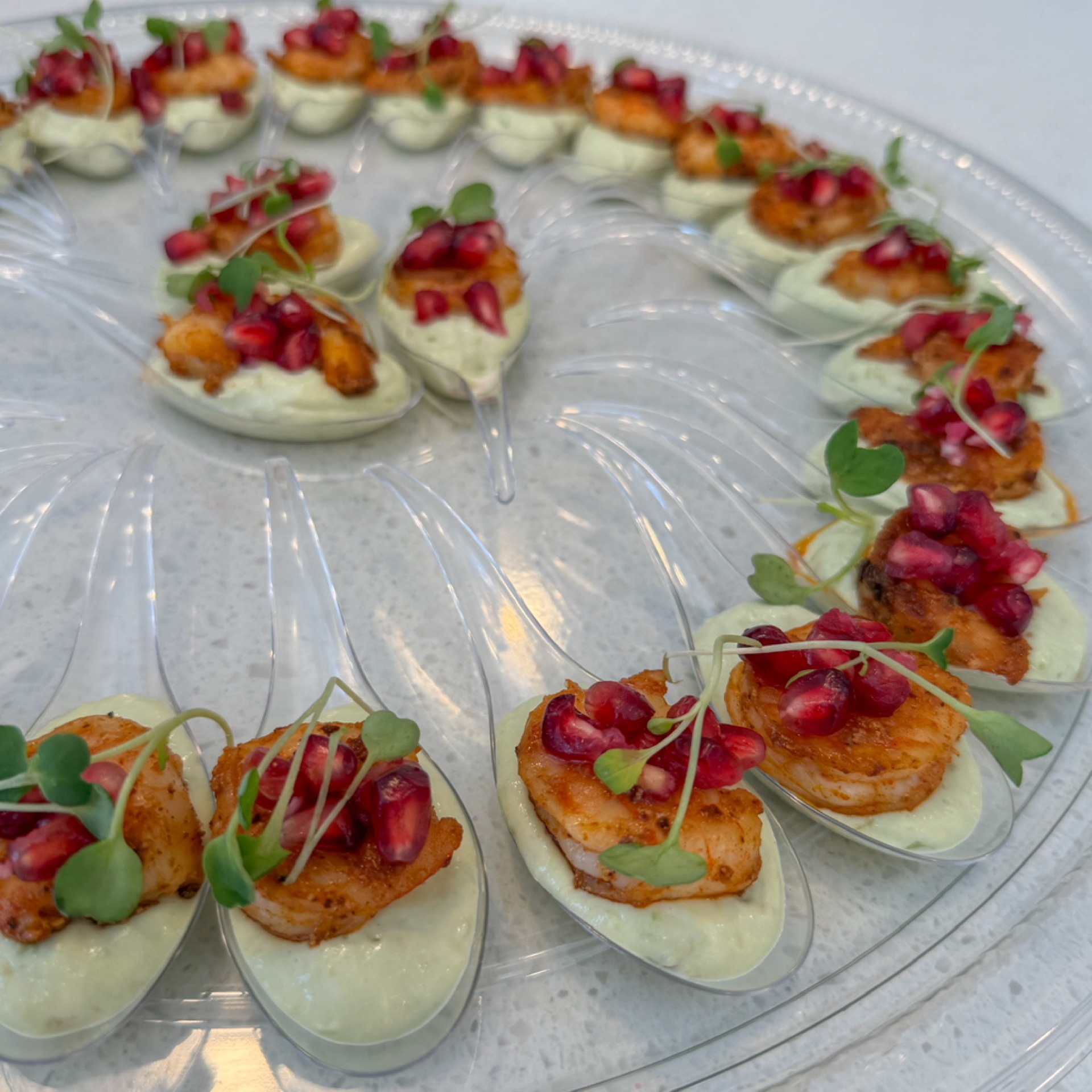 Tray of spoons: Cajun shrimp, avocado cream, and pomegranate
