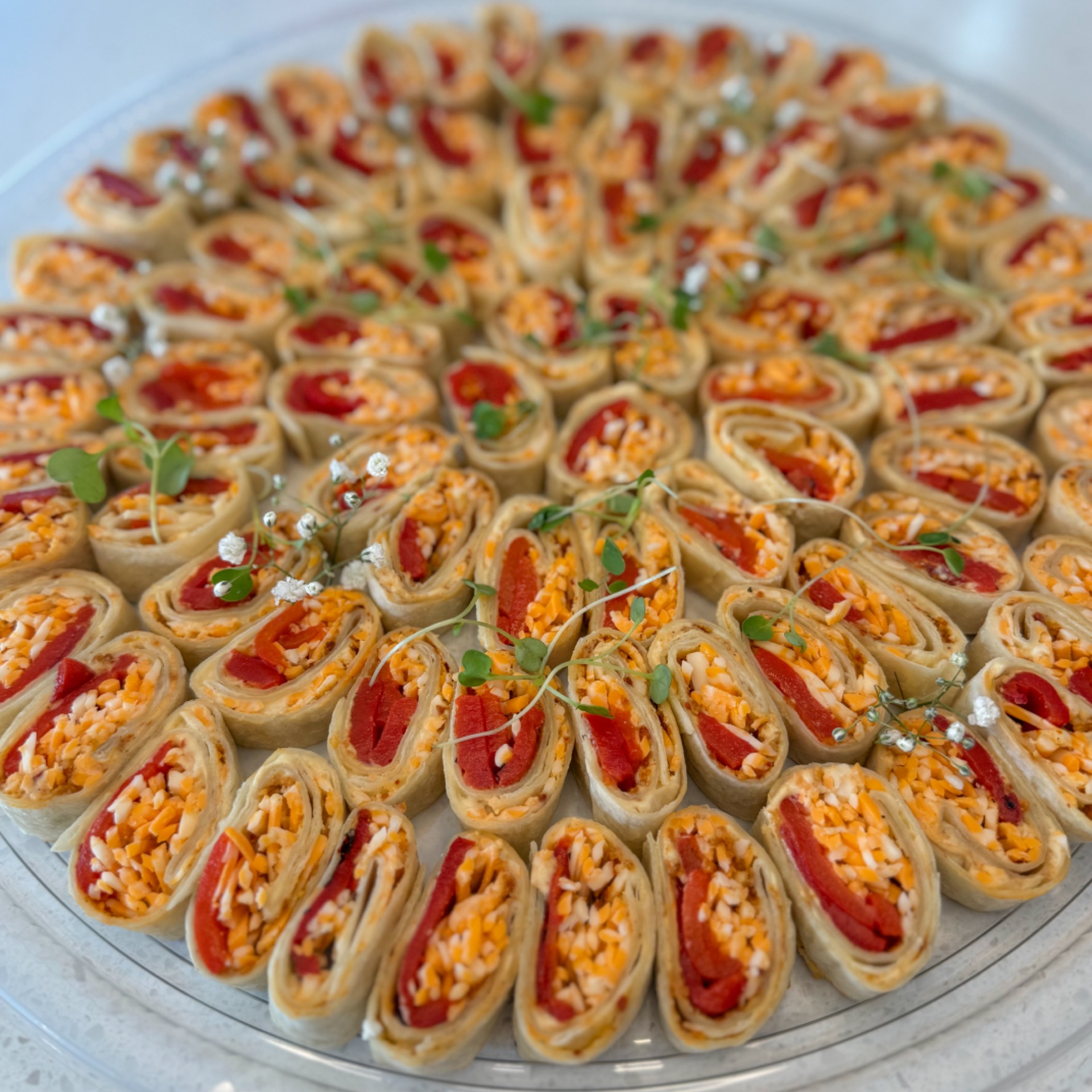 Veggie roll platter with roasted peppers, hummus and cheese