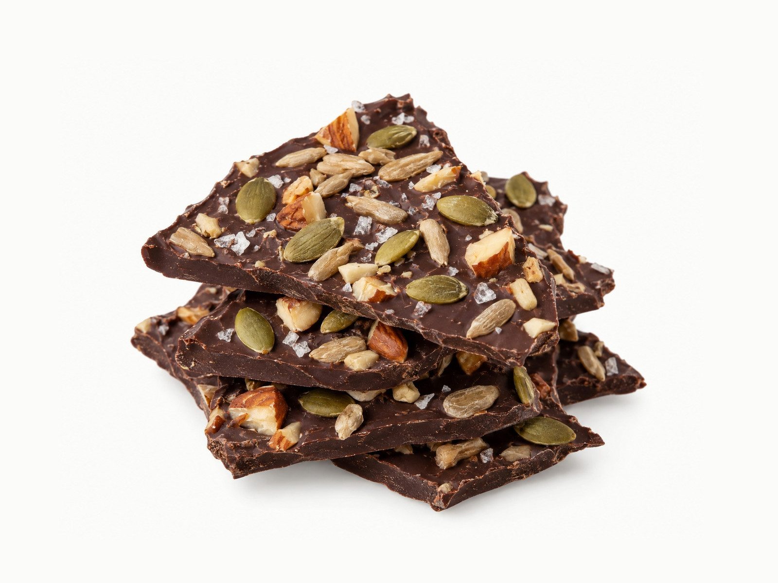 Stacked pieces of dark chocolate bark topped with pumpkin seeds, nuts and sea salt